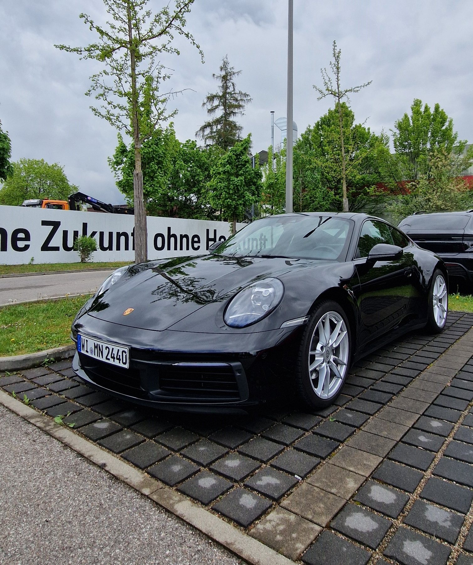 Μαύρη Porsche 911 Carrera παρκαρισμένη έξω από το Porsche Zentrum Olympiapark στο Μόναχο