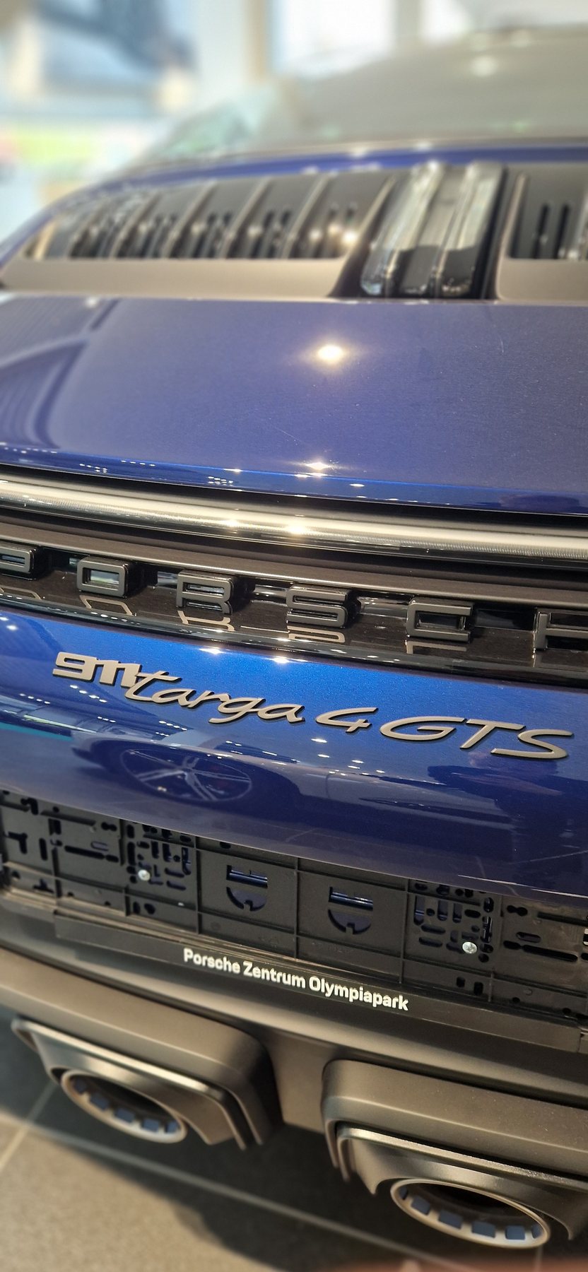 Το πίσω μέρος μιας μπλε Porsche 911 GT3 μέσα στο showroom