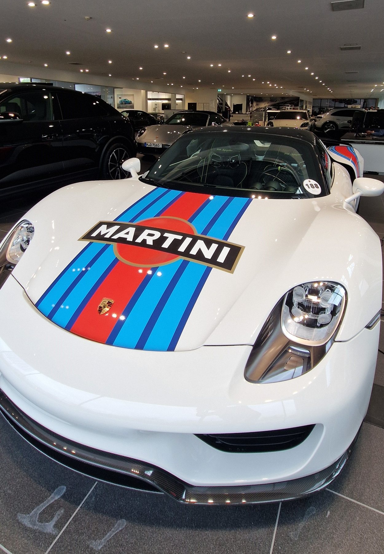 Porsche 918 Spyder με λευκό χρώμα και ρίγες Martini μέσα στο showroom
