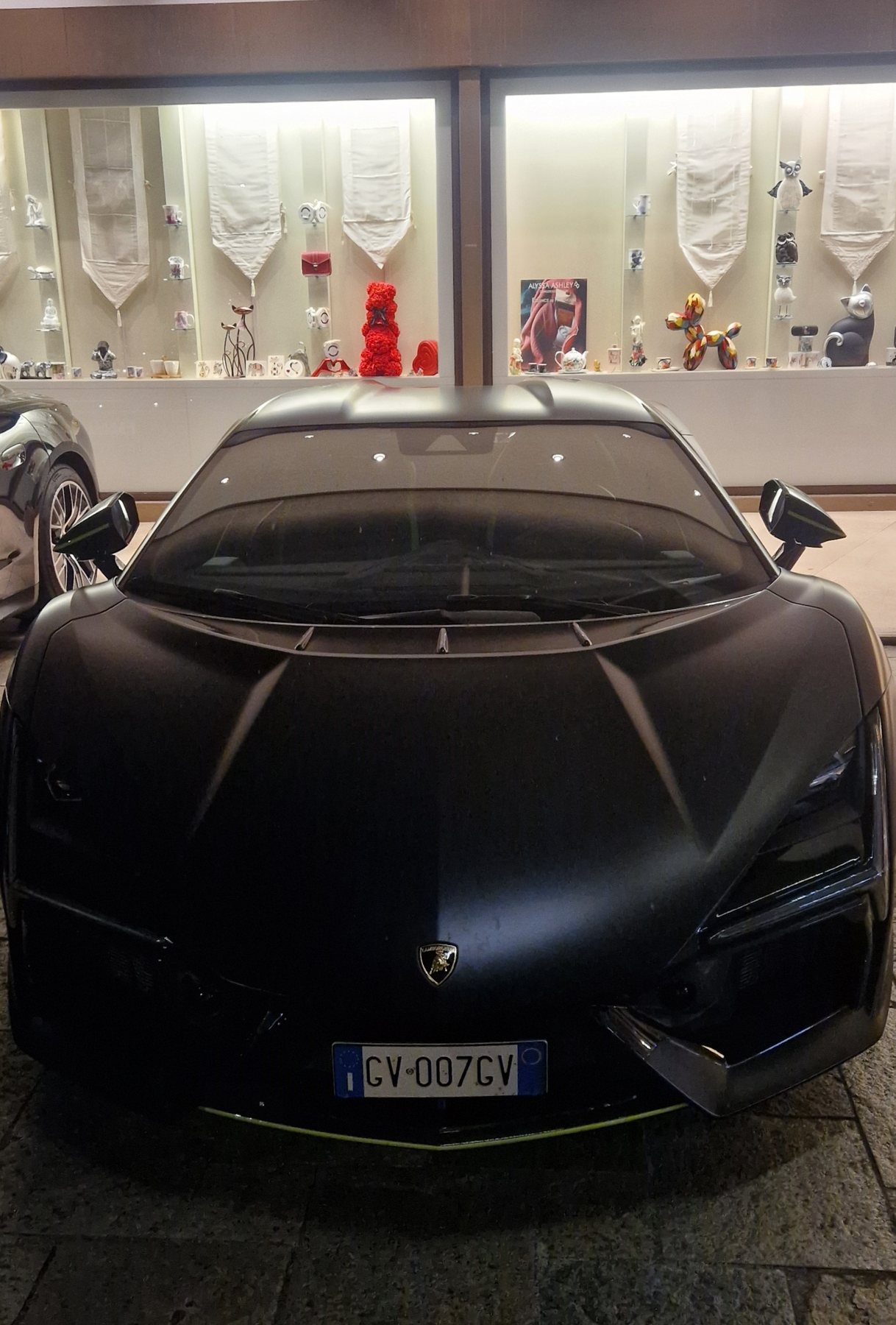 Μαύρη Lamborghini παρκαρισμένη μπροστά σε βιτρίνα κοσμηματοπωλείου