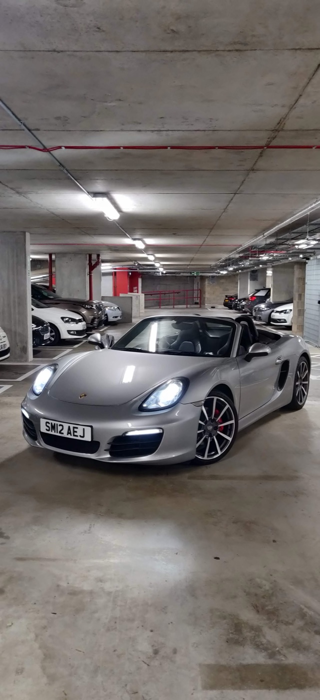 Το Boxster στο γκαράζ τη νύχτα, με αναμμένα φώτα και ανοιχτή οροφή