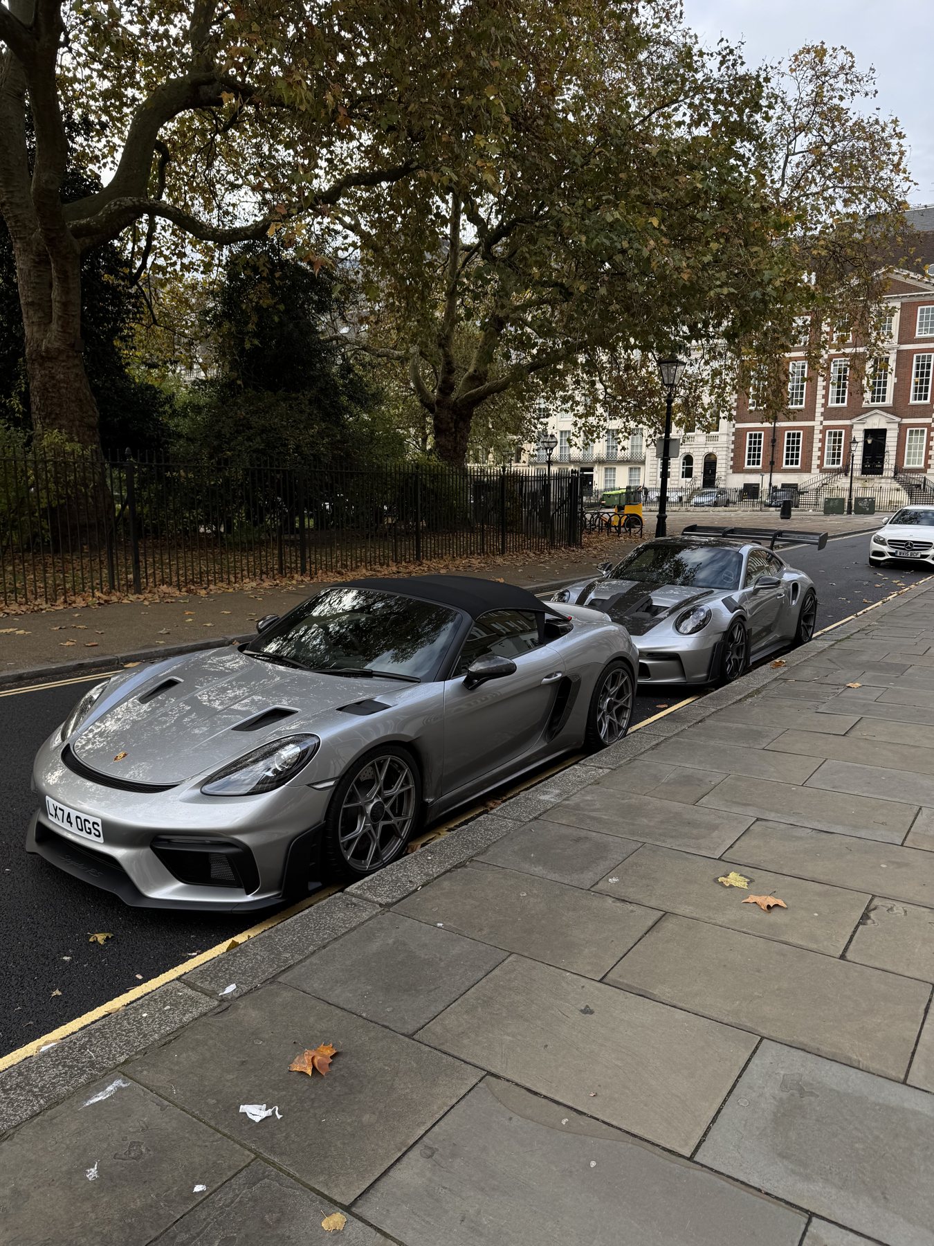 Ένα ασημί 718 Spyder RS και ένα GT3 RS παρκαρισμένα στην άκρη της πλατείας
