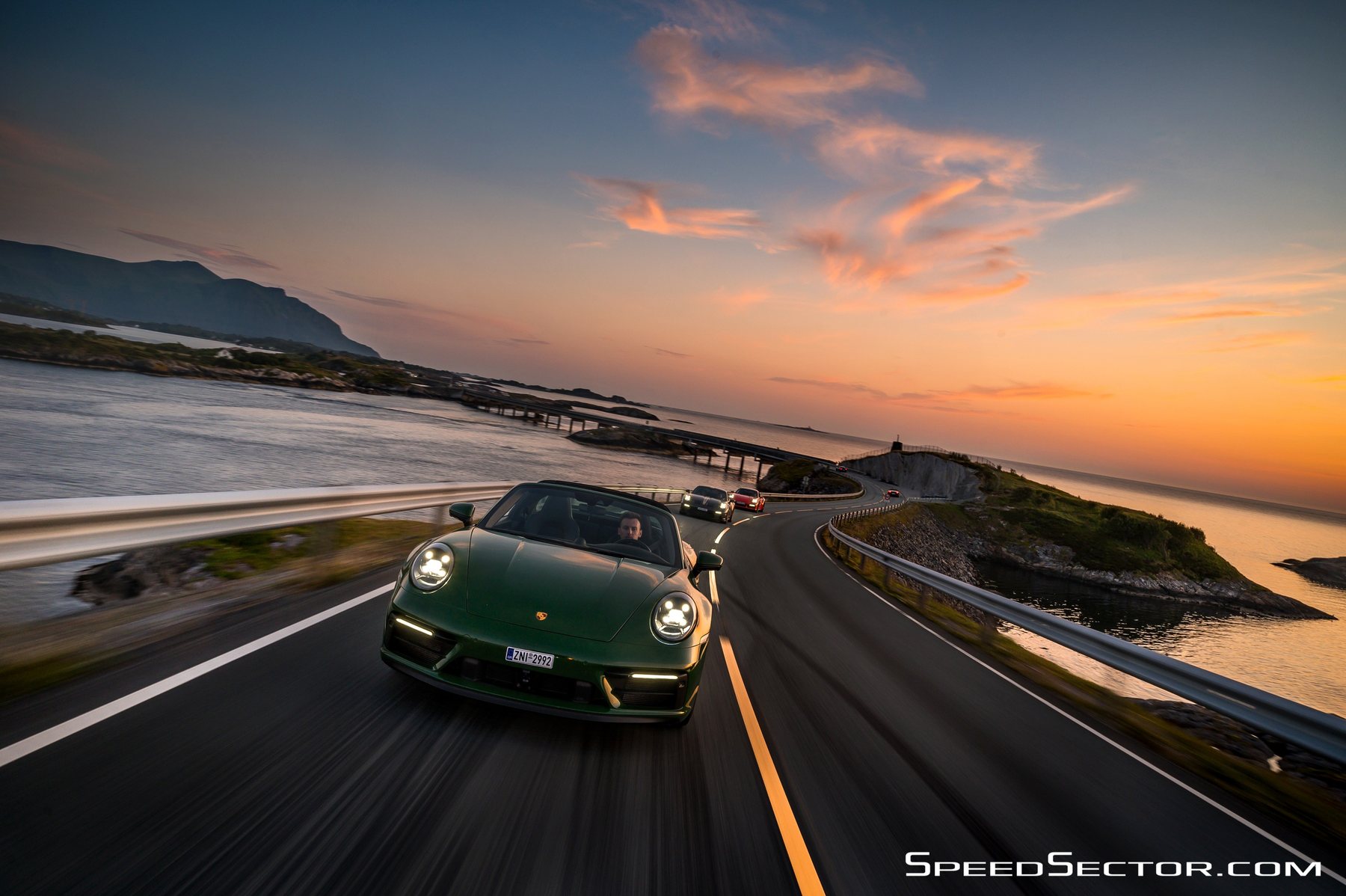 Η πράσινη 911 Targa τρέχει στο Atlantic Road, με τον ήλιο να δύει πάνω από τη θάλασσα