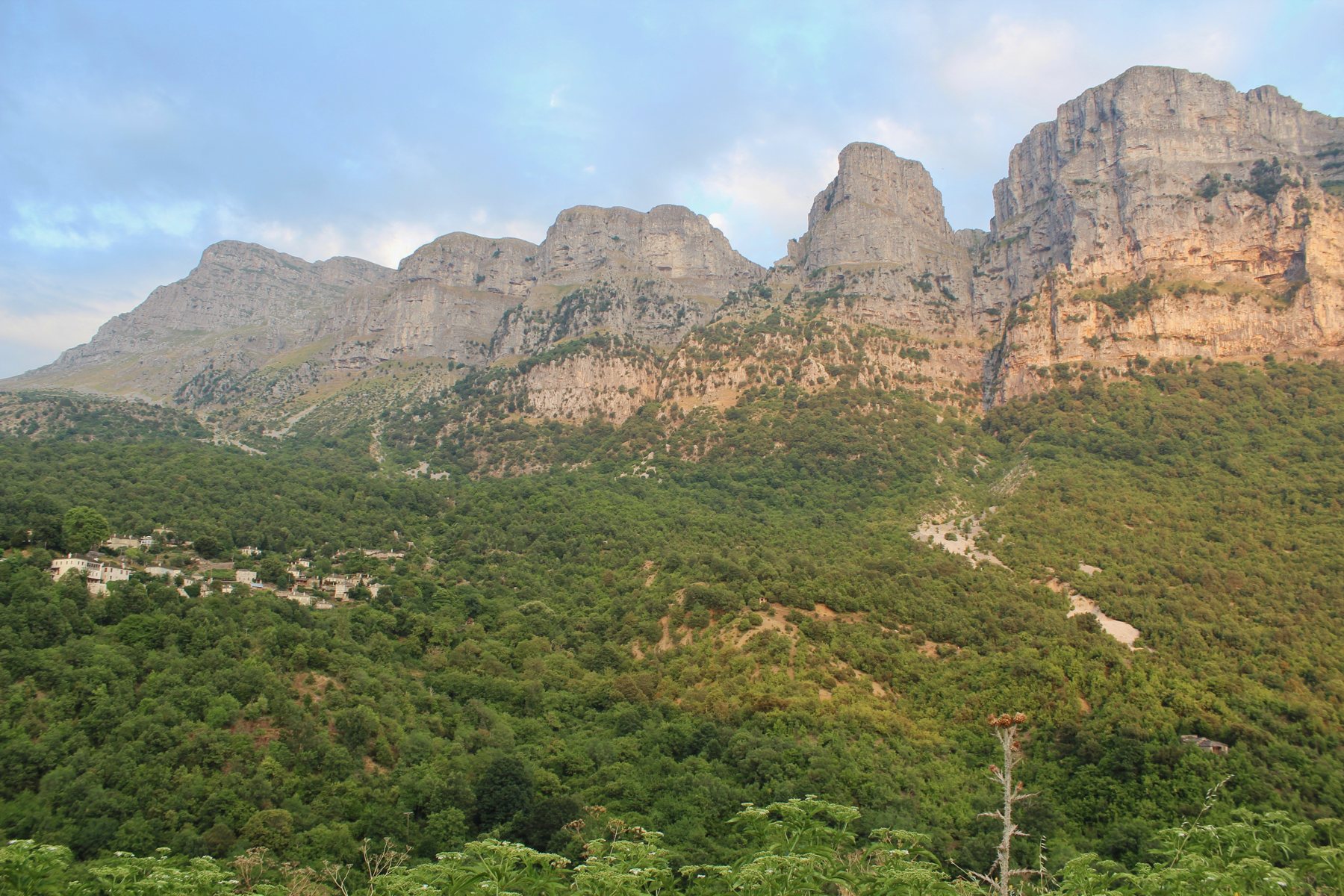 Mikro Papingo with its stone roofs below the cliffs of Astraka