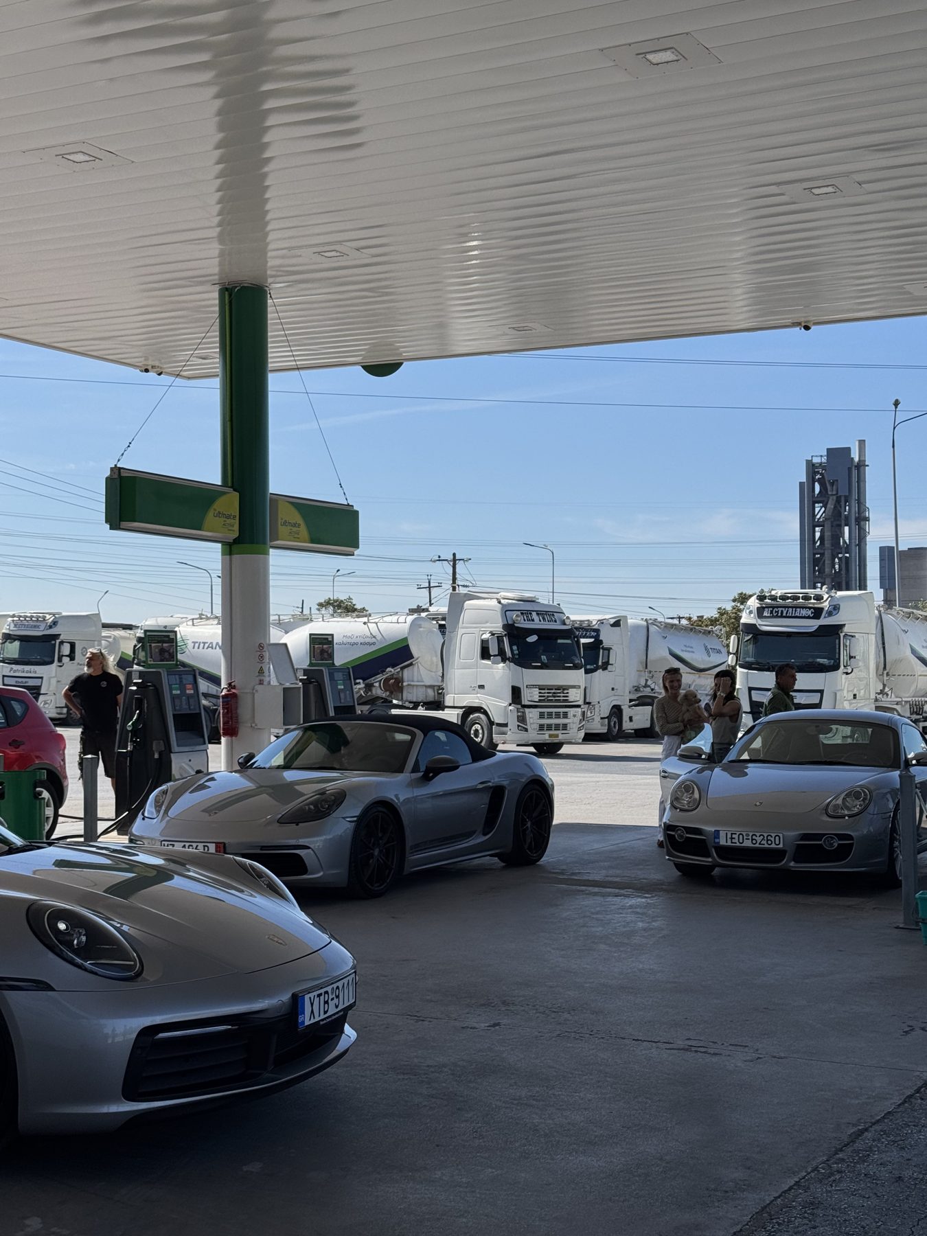 Οι τρεις Porsche στα πρατήρια του βενζινάδικου στο Δερβένι, με φορτηγά στο βάθος